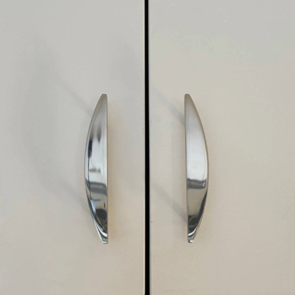 half moon polished nickel pulls installed on white cabinets