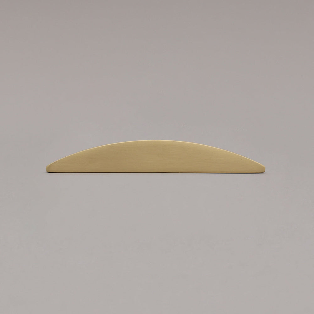 half moon satin brass gold laying on gray background