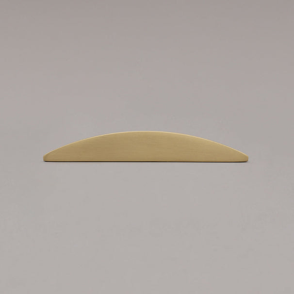 half moon satin brass gold laying on gray background