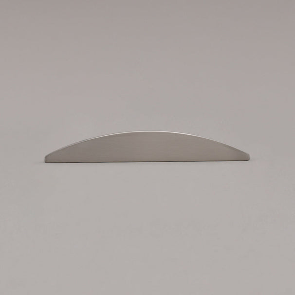 small satin nickel half moon pull laying on gray background