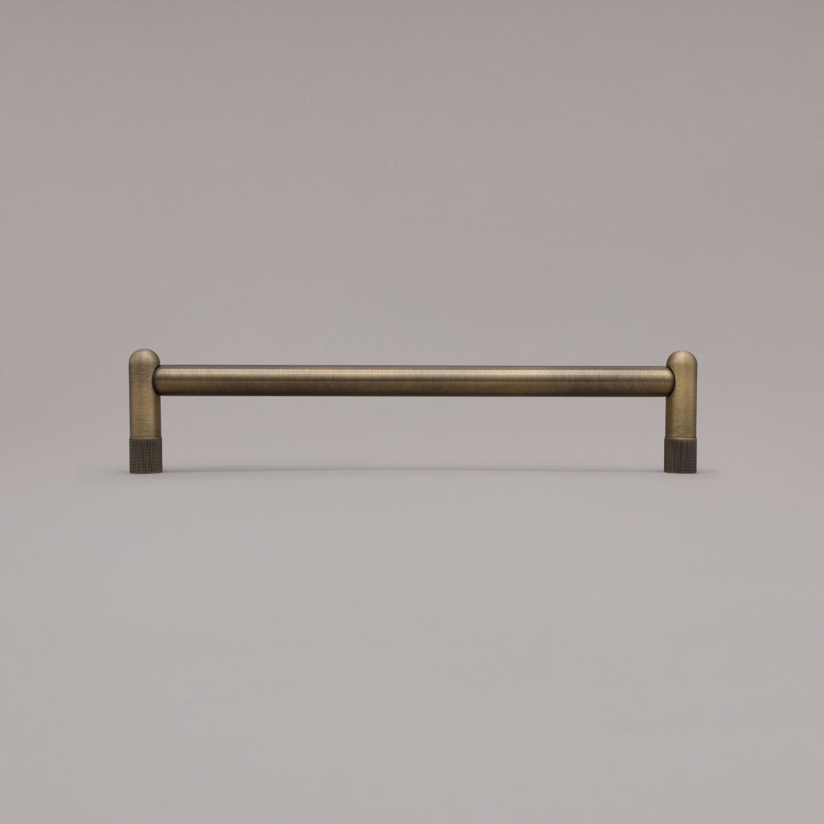 12" knurled appliance pull in aged brass standing on gray background