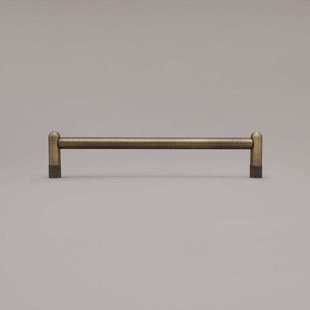 12" knurled appliance pull in aged brass standing on gray background