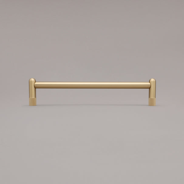 12" knurled appliance pull in satin brass standing on gray background