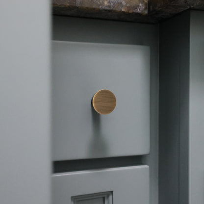 Close-up of a blue drawer with an aged brass knob
