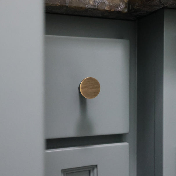 Close-up of a blue drawer with an aged brass knob