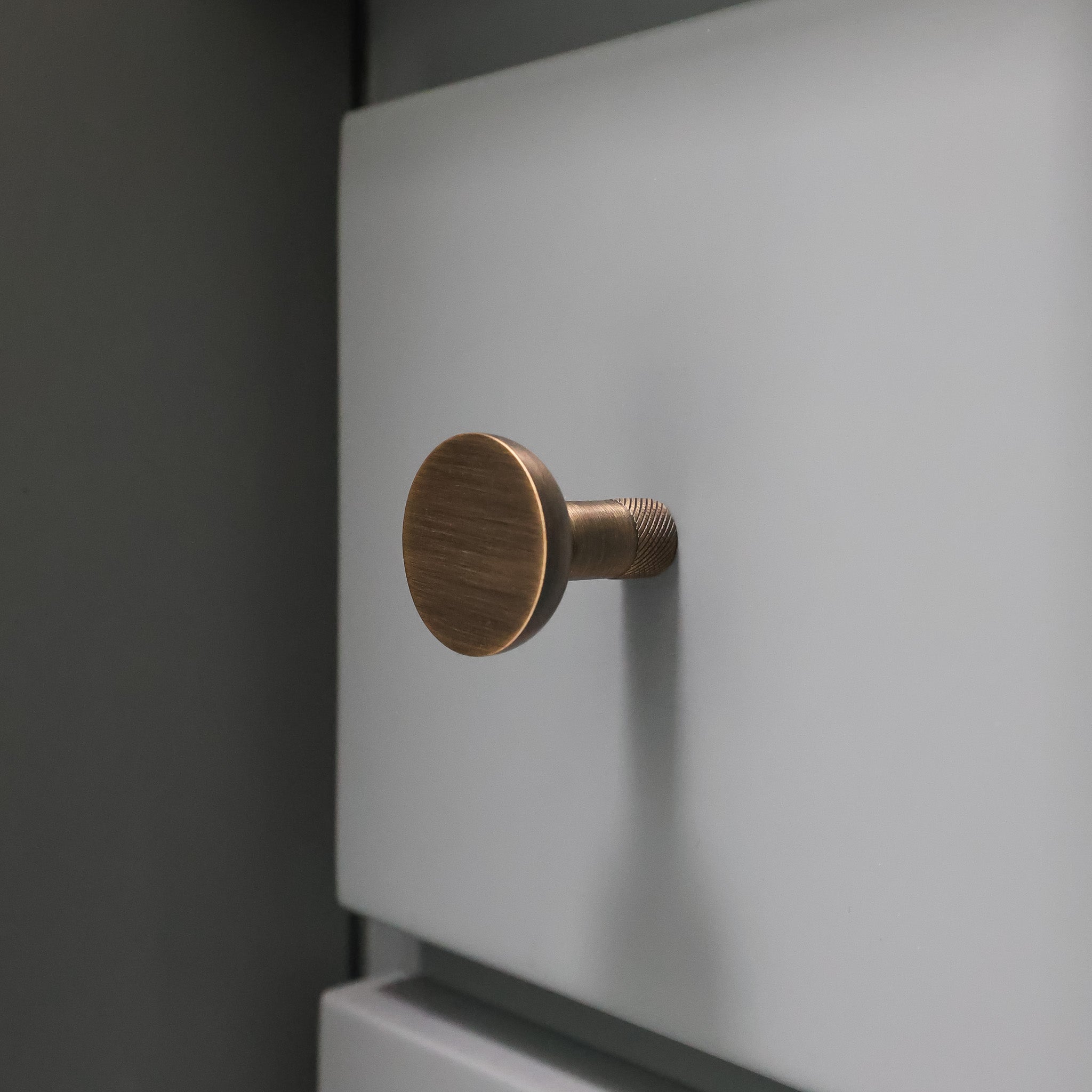 Aged Brass door handle on a white door with a dark background