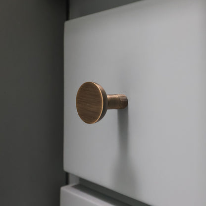 Aged Brass door handle on a white door with a dark background