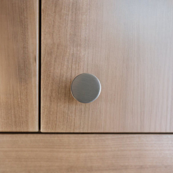Close-up of a knurled satin nickel knob on kitchen cabinet.