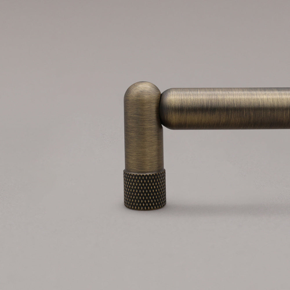 close up of knurled stem in aged brass on gray background