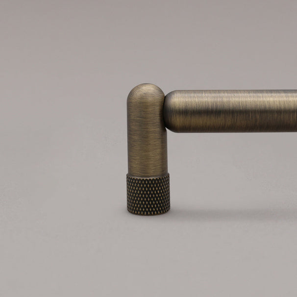 close up of knurled stem in aged brass on gray background