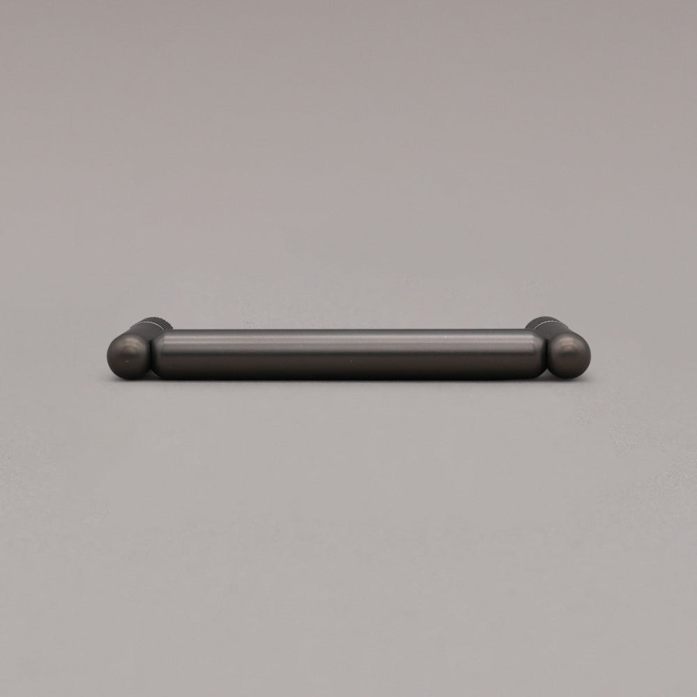 knurled graphite pull laying on gray background