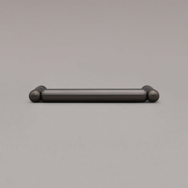 knurled graphite pull laying on gray background