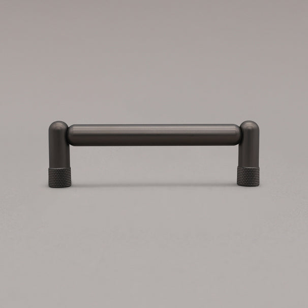 standing knurled graphite cabinet pull on gray background