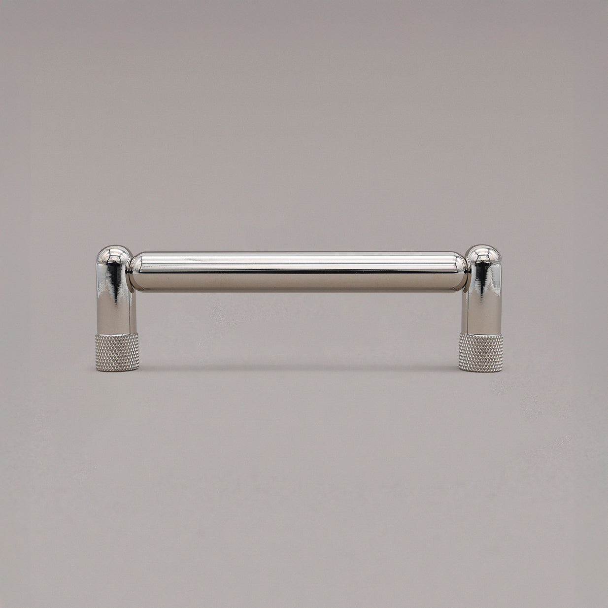 standing knurled polished nickel cabinet pull on gray background