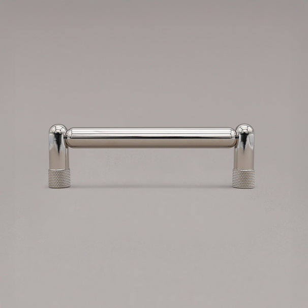 standing knurled polished nickel cabinet pull on gray background