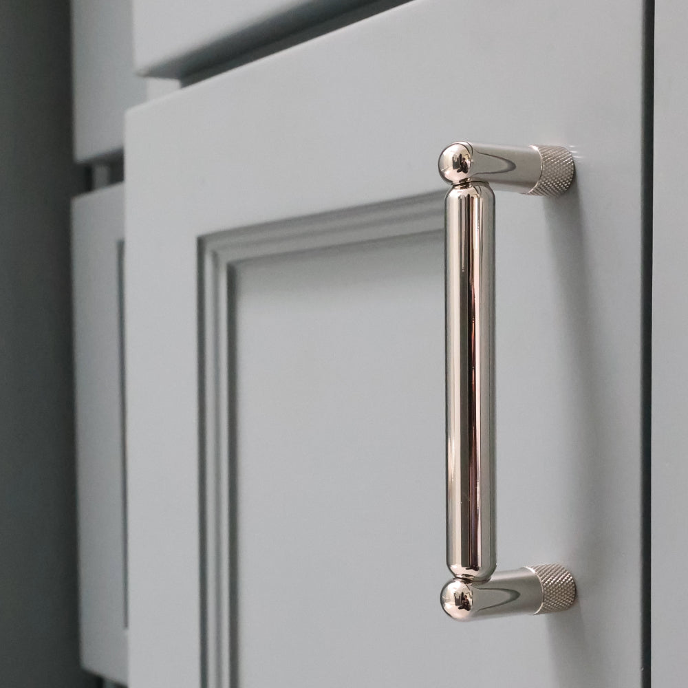 knurled polished nickel pull installed on blue bathroom cabinet door