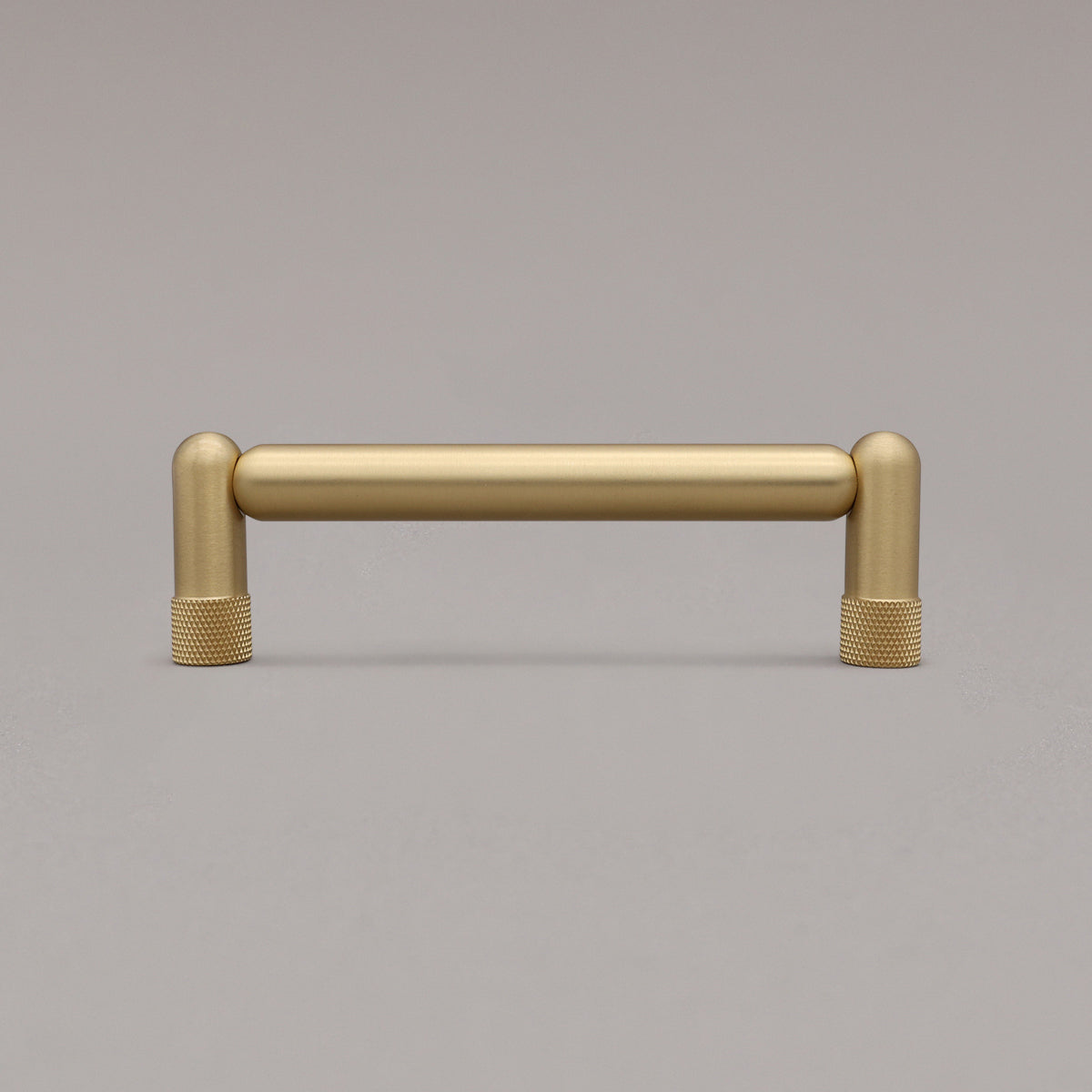 standing knurled satin brass gold cabinet pull on gray background