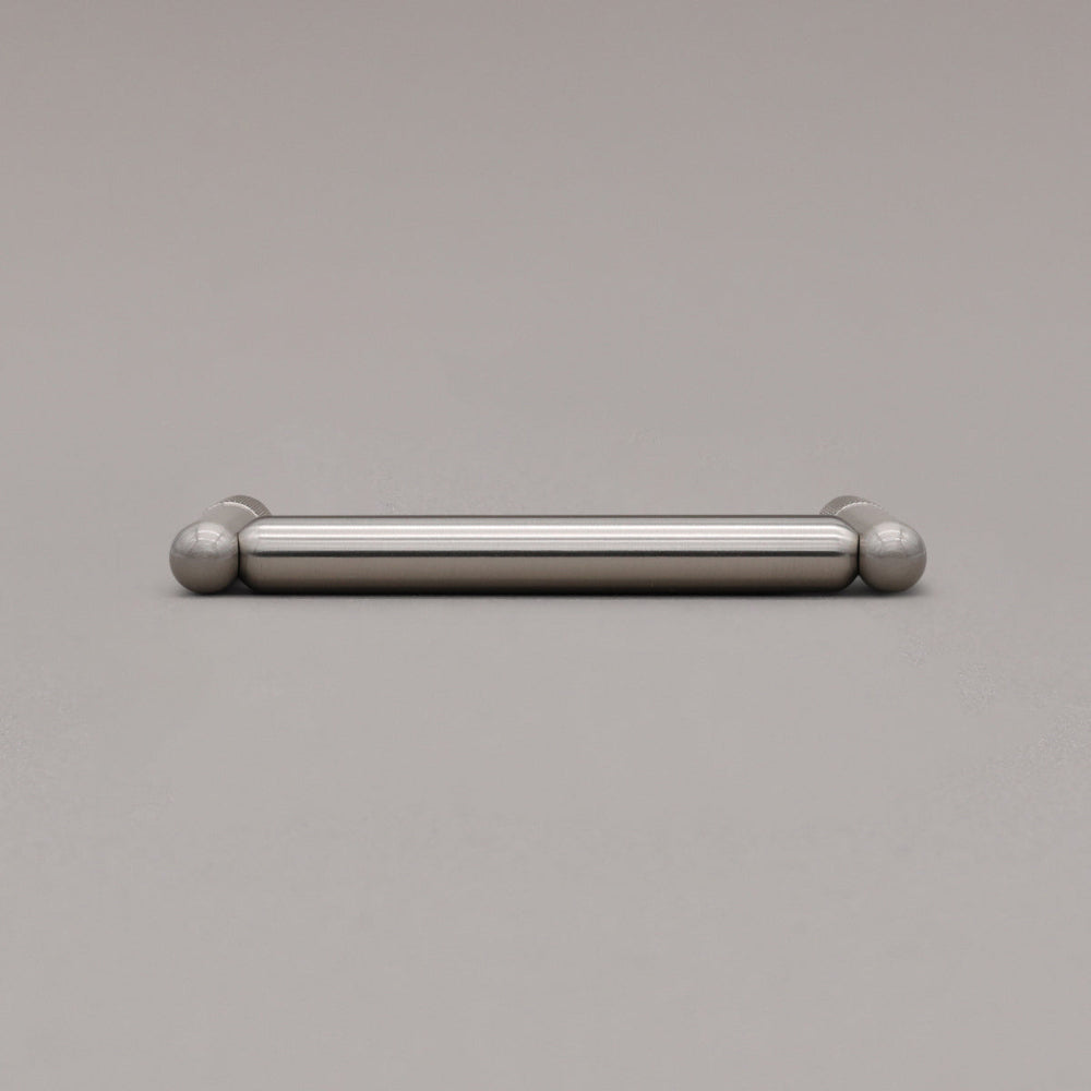 satin nickel silver knurled cabinet pull laying ong ray background