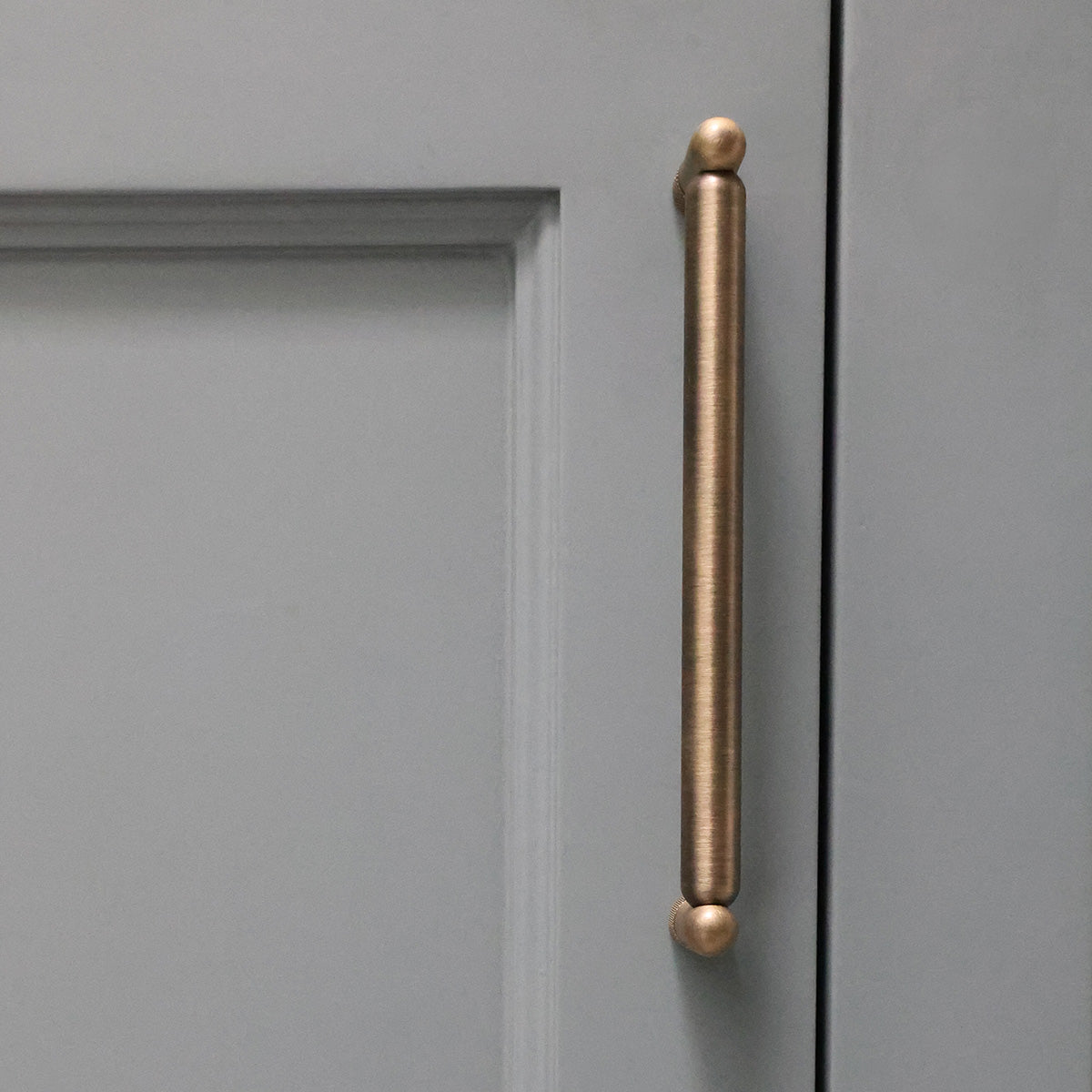 Aged brass cabinet handle on a blue cabinet door