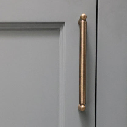 Aged brass cabinet handle on a blue cabinet door