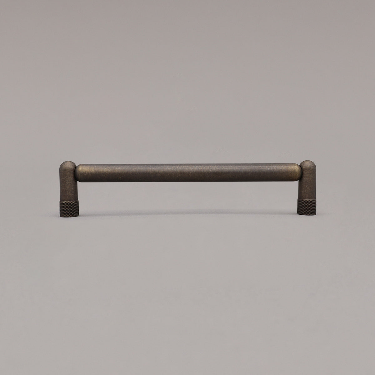 Medium antique english knurled cabinet pull standing on gray background