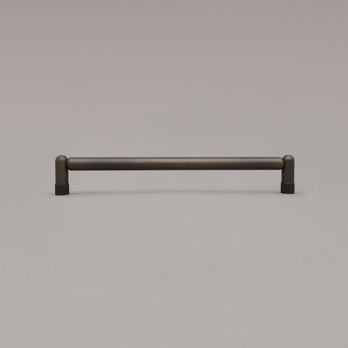 Large antique english knurled cabinet pull standing on gray background