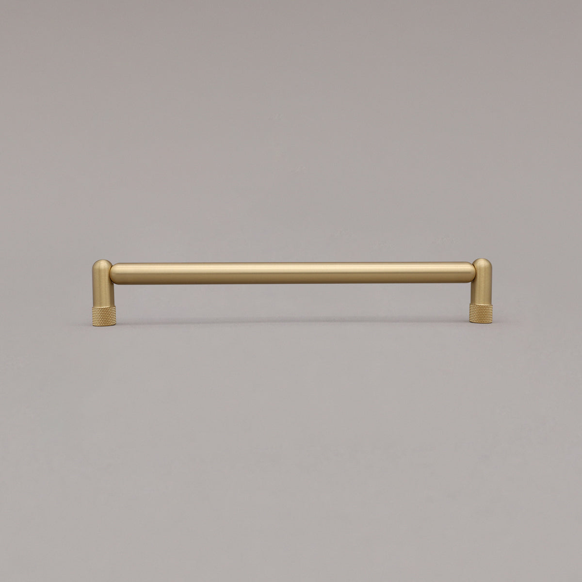 Large satin brass gold knurled cabinet pull standing on gray background