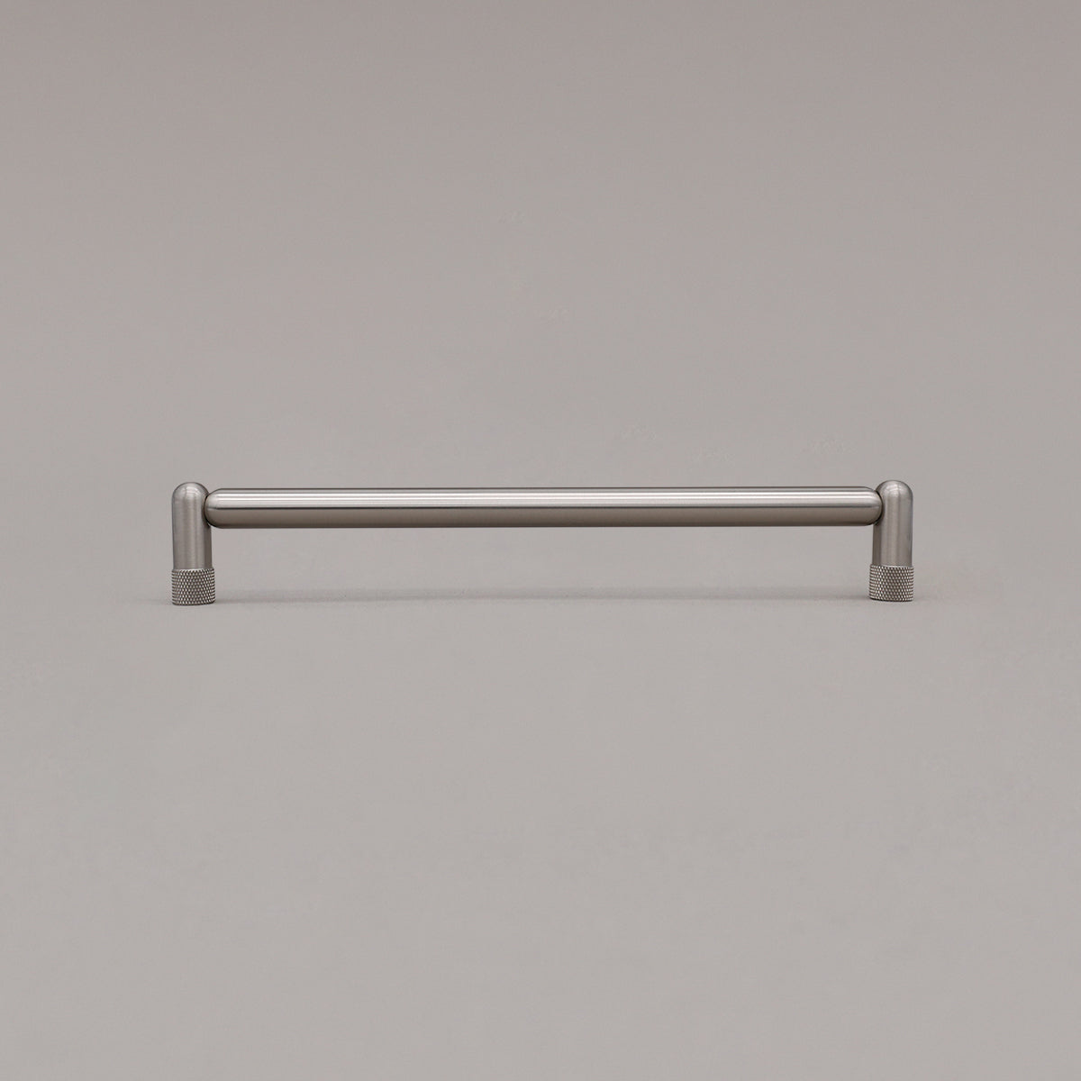 Large satin nickel silver knurled cabinet pull standing on gray background