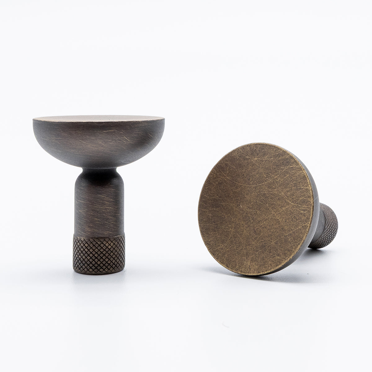 Two antique english finished brass cabinet knobs on a white background.