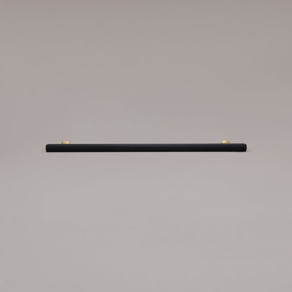 18" Mod appliance pull in Black and Satin Brass laying on gray background