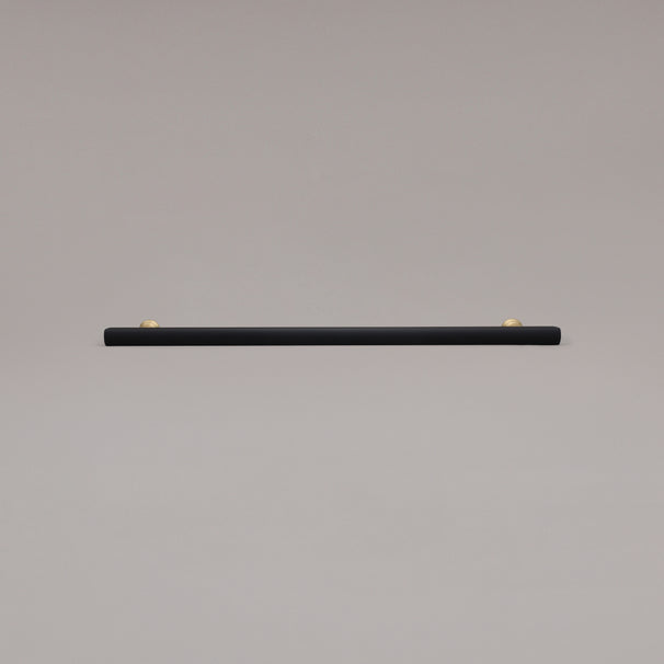 18" Mod appliance pull in Black and Satin Brass laying on gray background