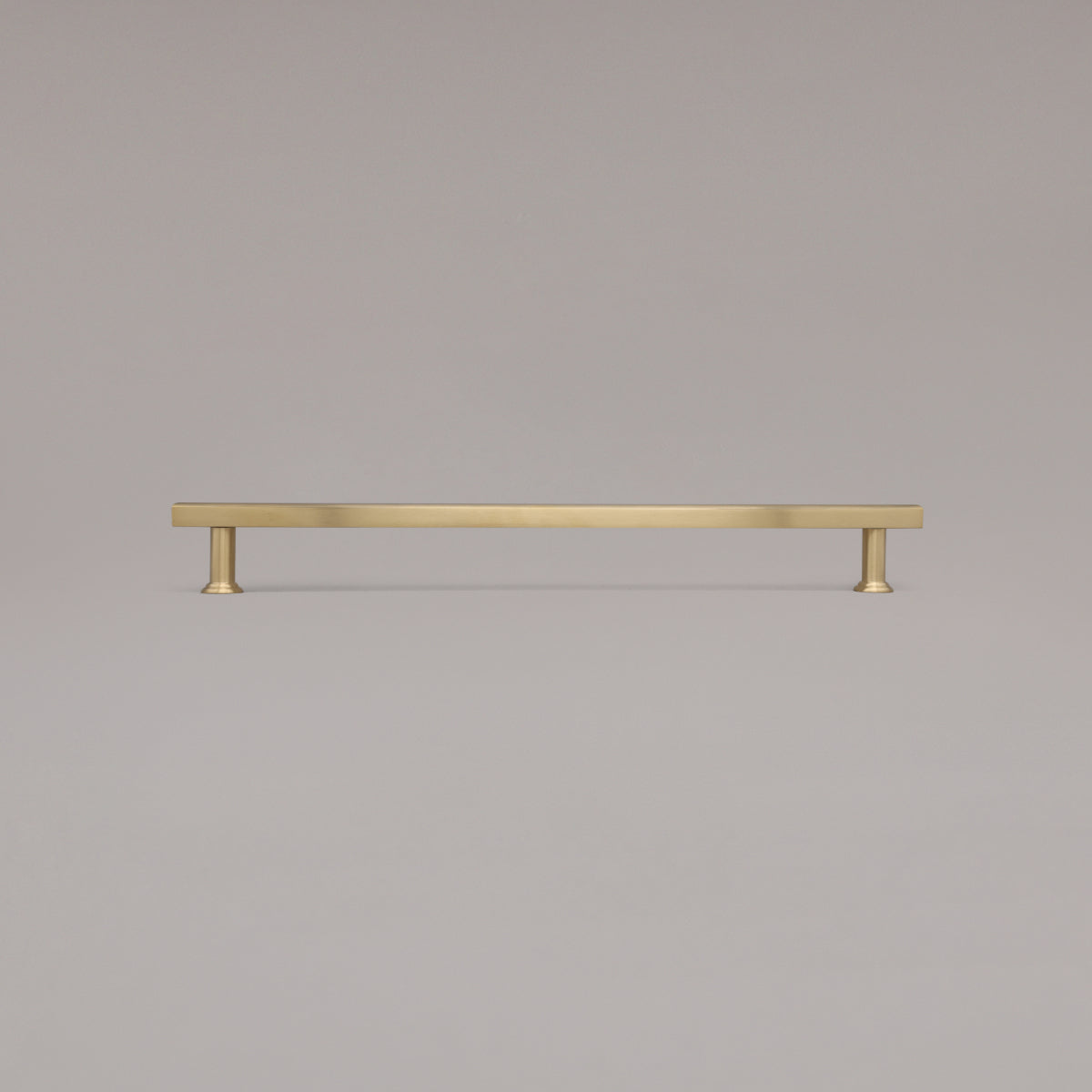 18" Mod appliance pull in Unlacquered Satin Brass standing on gray background