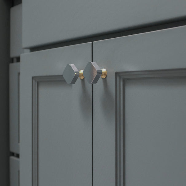 Polished chrome and brass two tone diamond knobs installed on blue bathroom cabinets
