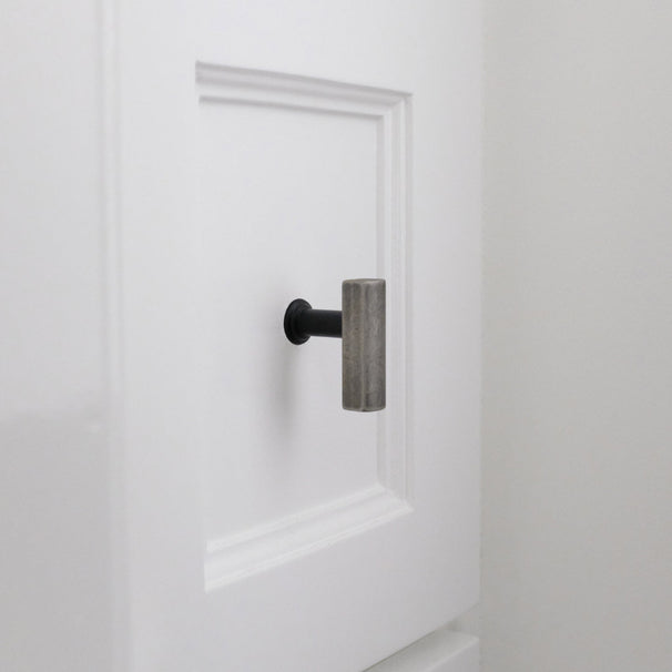 White bathroom drawer with matte black and weathered nickel  t-knob brass cabinet knob.