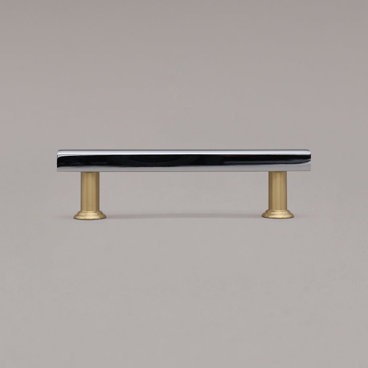 chrome and satin brass mod cabinet pull standing on gray background