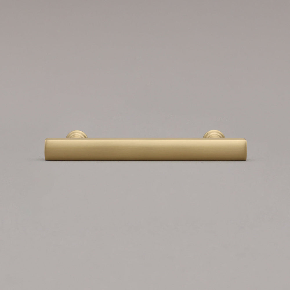 satin brass gold mod cabinet pull laying on gray background