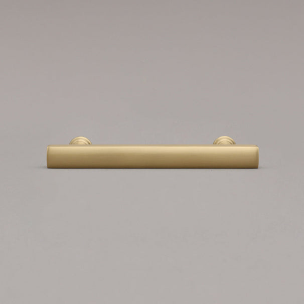 satin brass gold mod cabinet pull laying on gray background