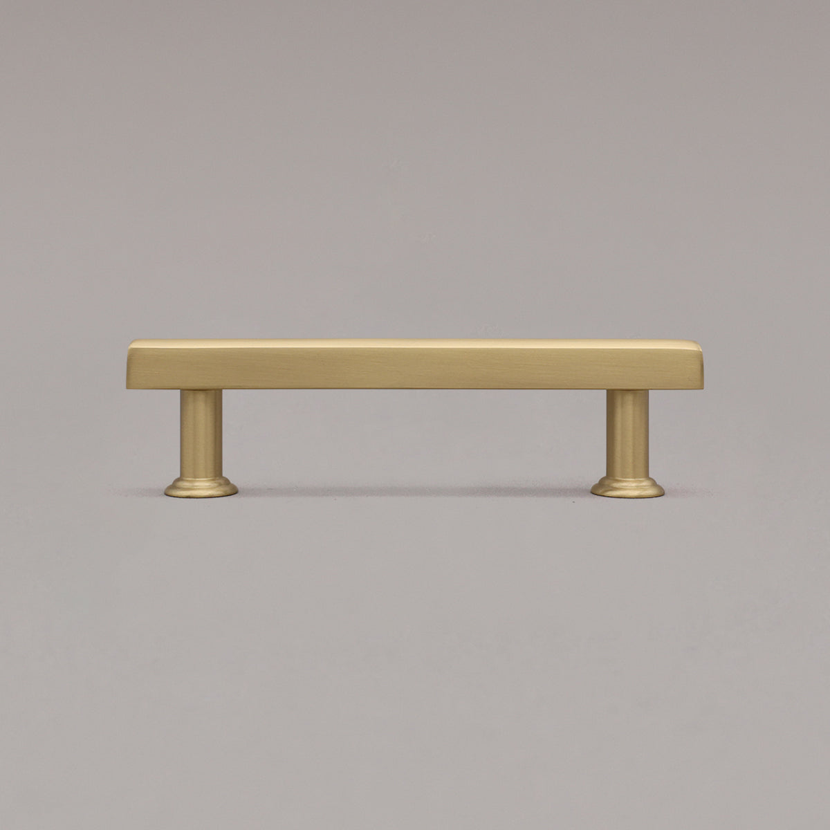 satin brass mod cabinet pull standing on gray background