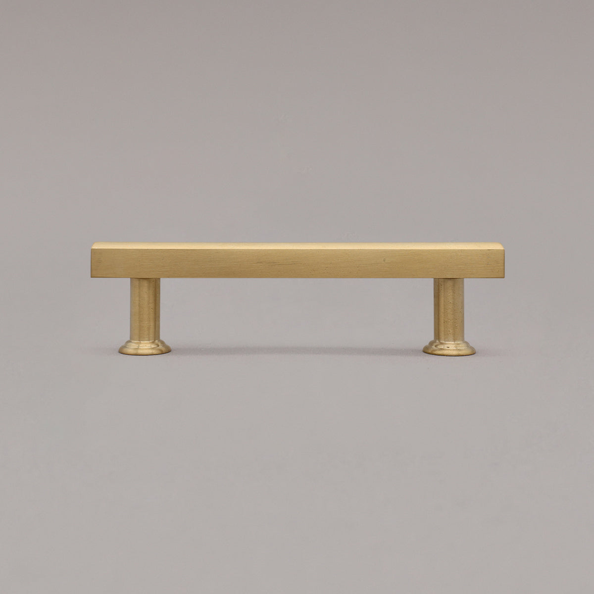 unlacquered satin brass mod cabinet pull standing on gray background