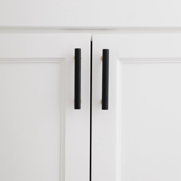 black and brass mod cabinet pulls installed on white cabinets