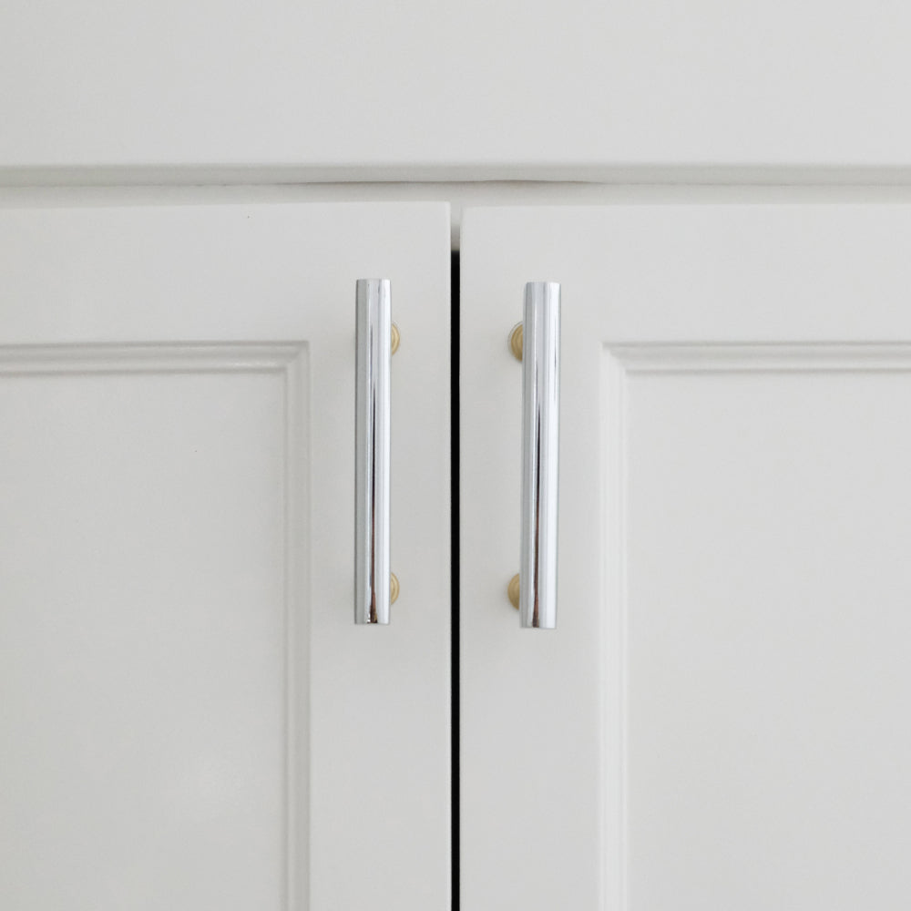 polished chrome and satin brass pulls installed on white cabinets