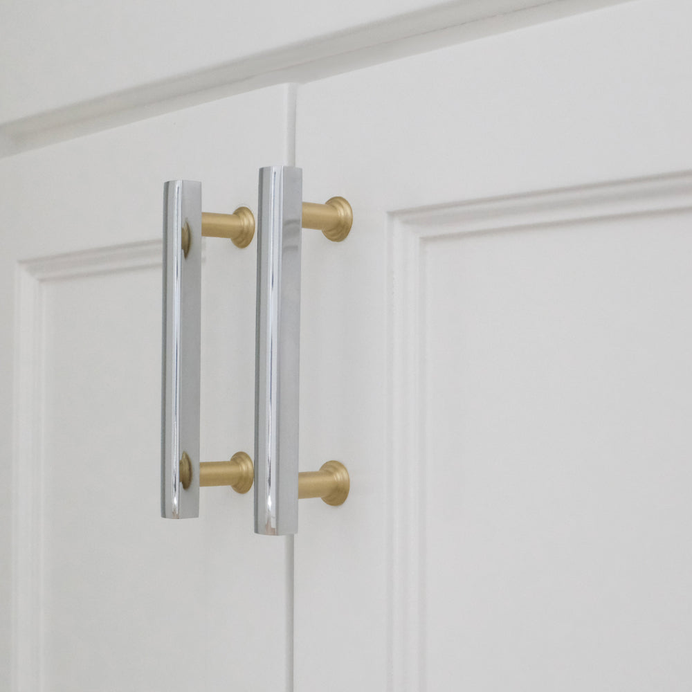 polished chrome and satin brass pulls installed on white cabinets