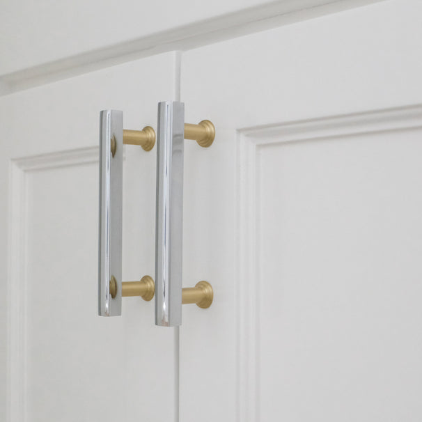 polished chrome and satin brass pulls installed on white cabinets