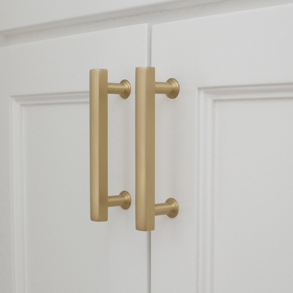 white satin brass mod cabinet pulls installed on white background