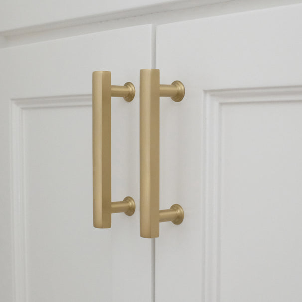 white satin brass mod cabinet pulls installed on white background