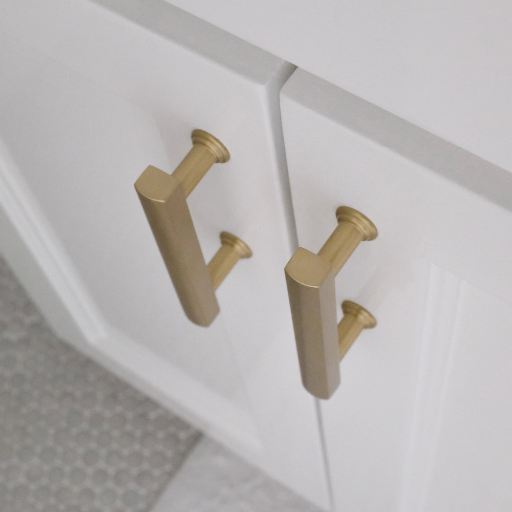 top view of satin brass mod cabinet pulls installed on white background