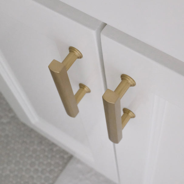 top view of satin brass mod cabinet pulls installed on white background
