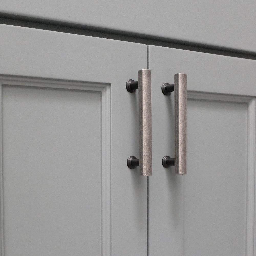 weathered nickel and matte black cabinet pulls installed on blue cabinets