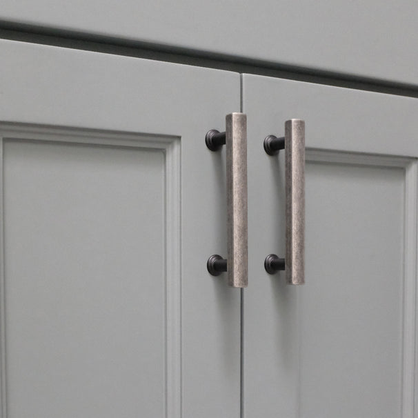weathered nickel and matte black cabinet pulls installed on blue cabinets
