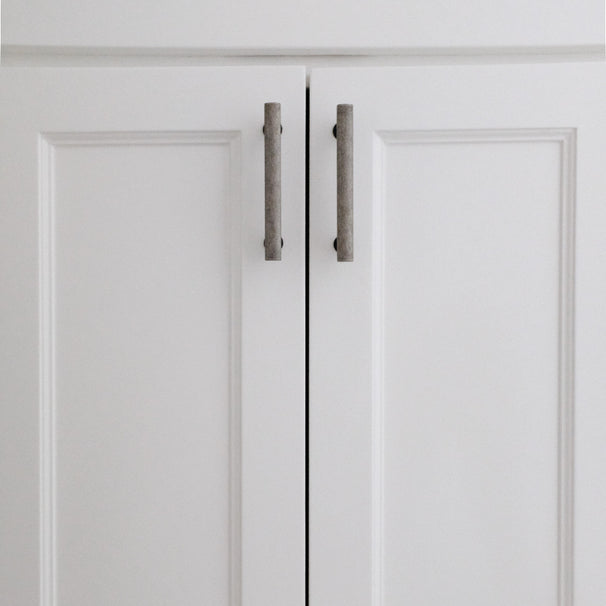 weathered nickel and matte black handles on white cabinets